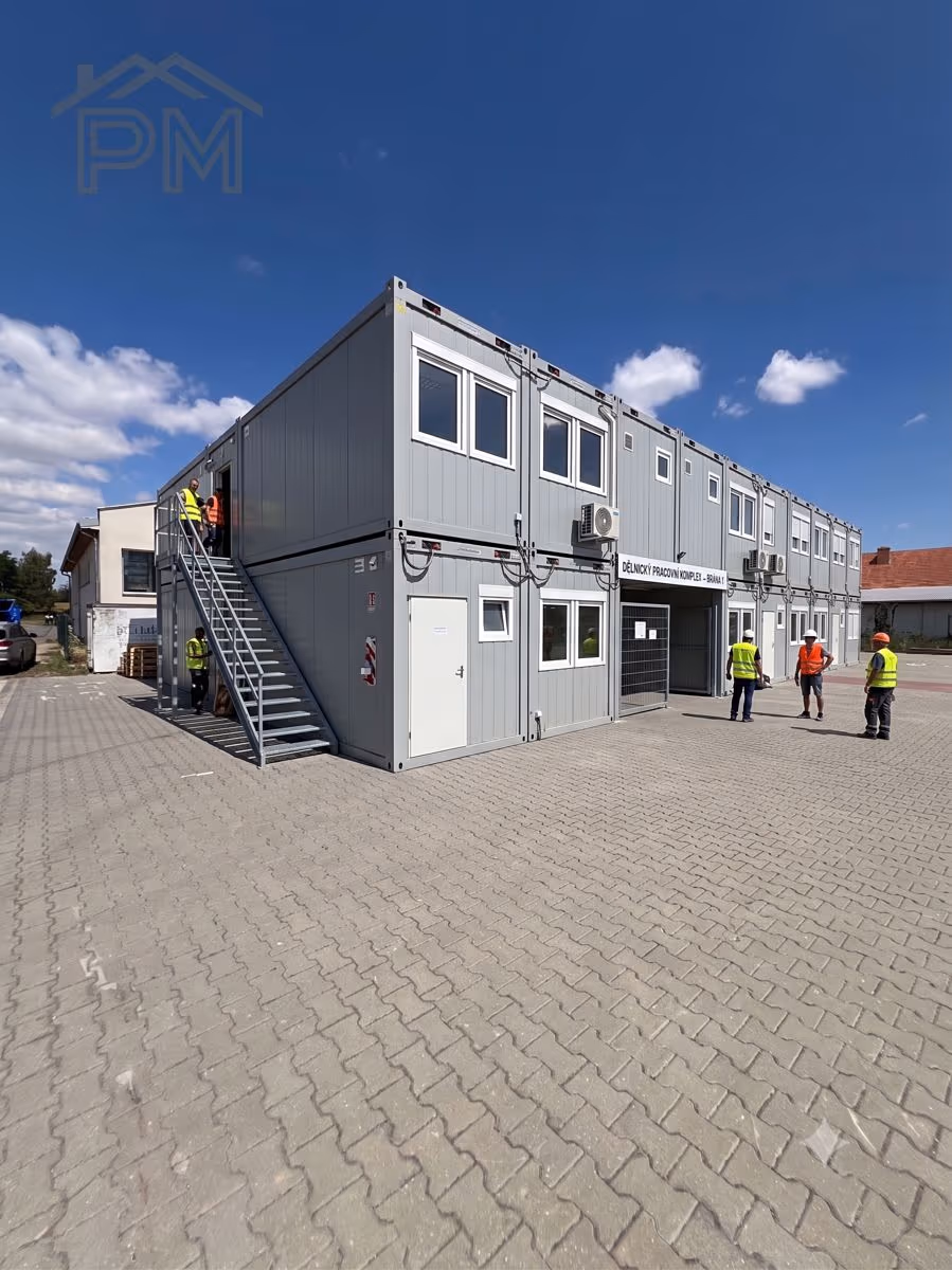 Dvoupodlažní kontejnerový komplex s venkovním schodištěm — příklad demontovatelné stavby
