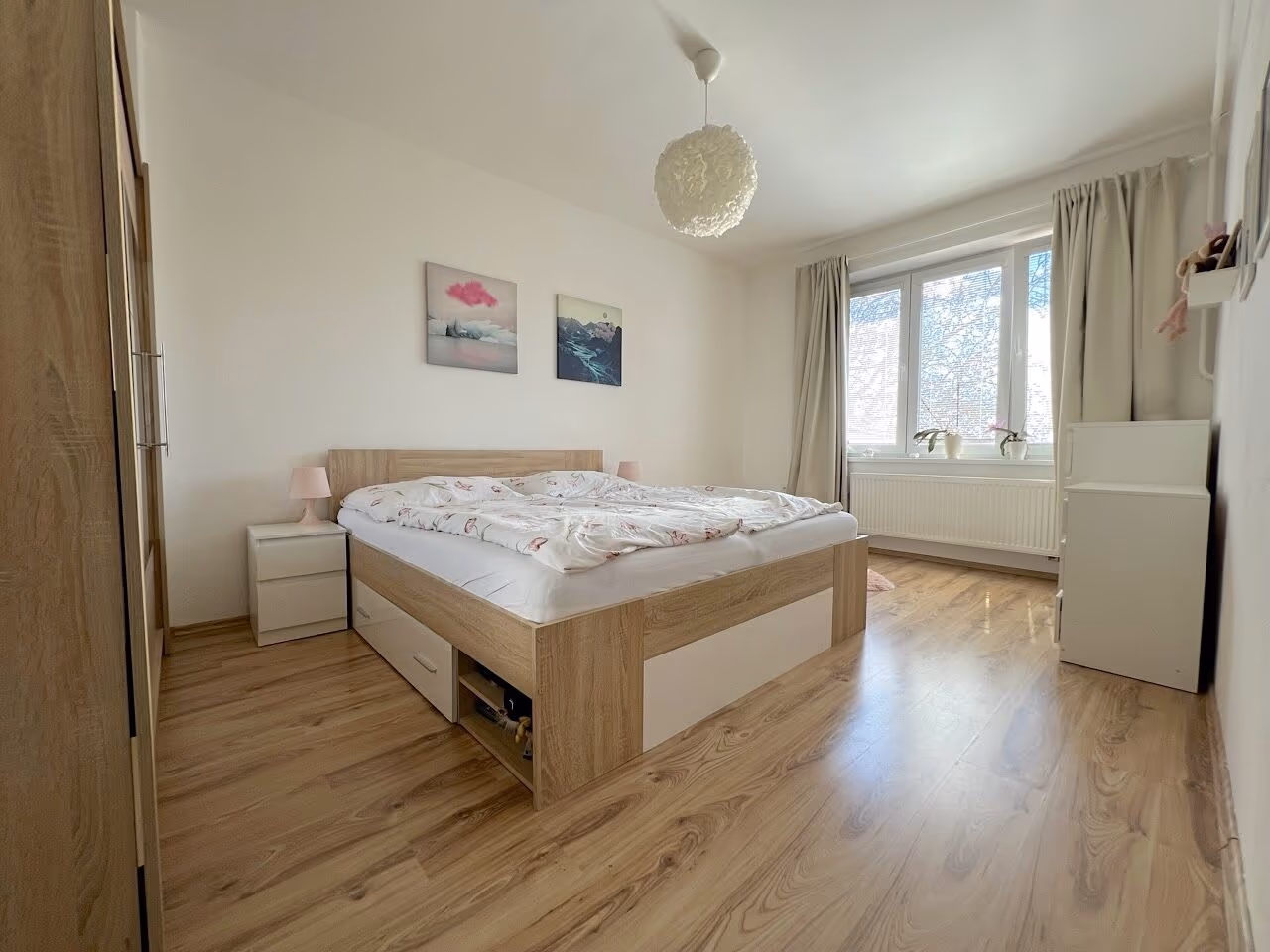 Ložnice s manželskou postelí, šatní skříní a oknem s radiátorem
