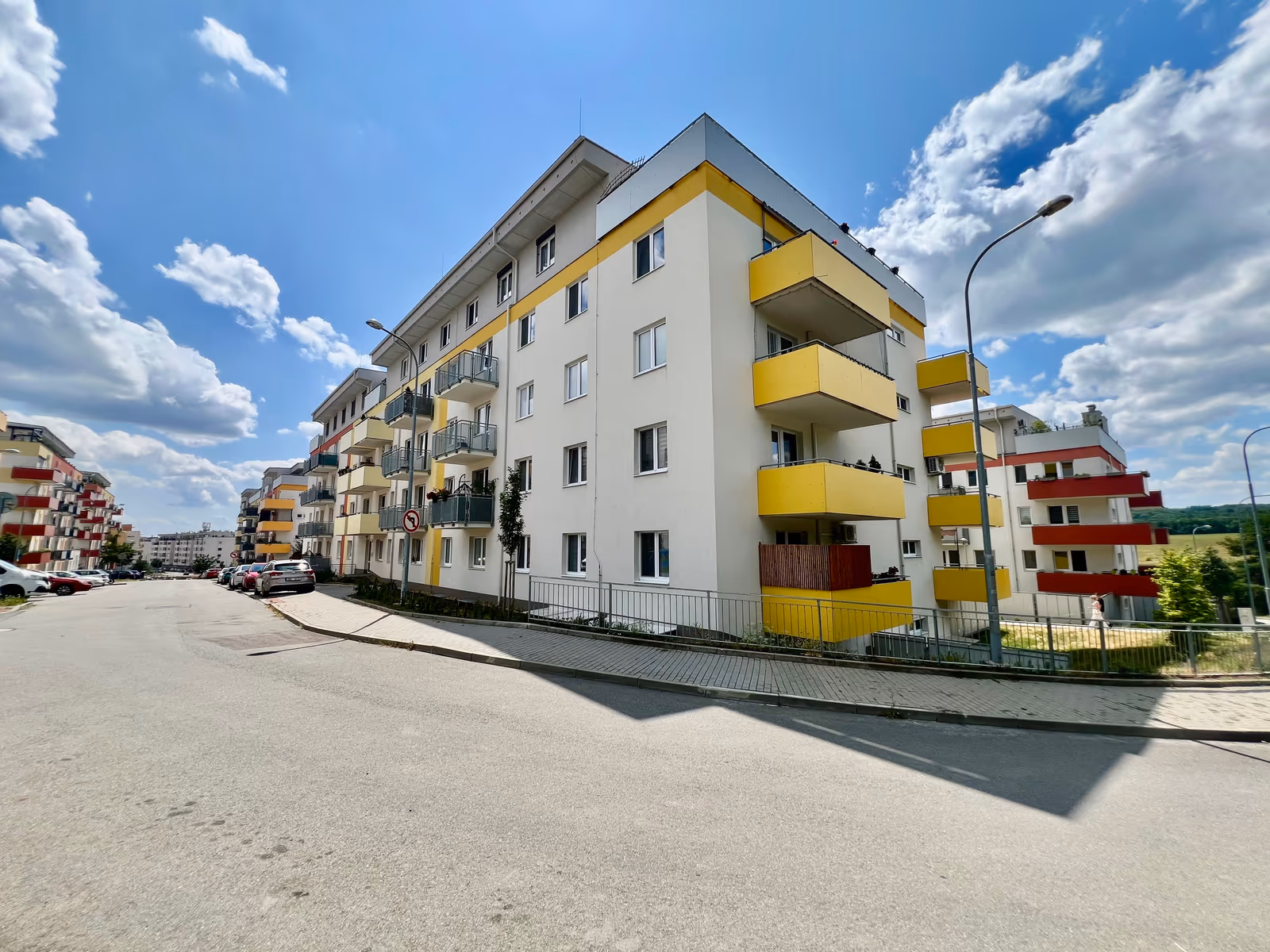 Bytový dům na ulici Hlinecká se žlutými balkony, pohled z ulice