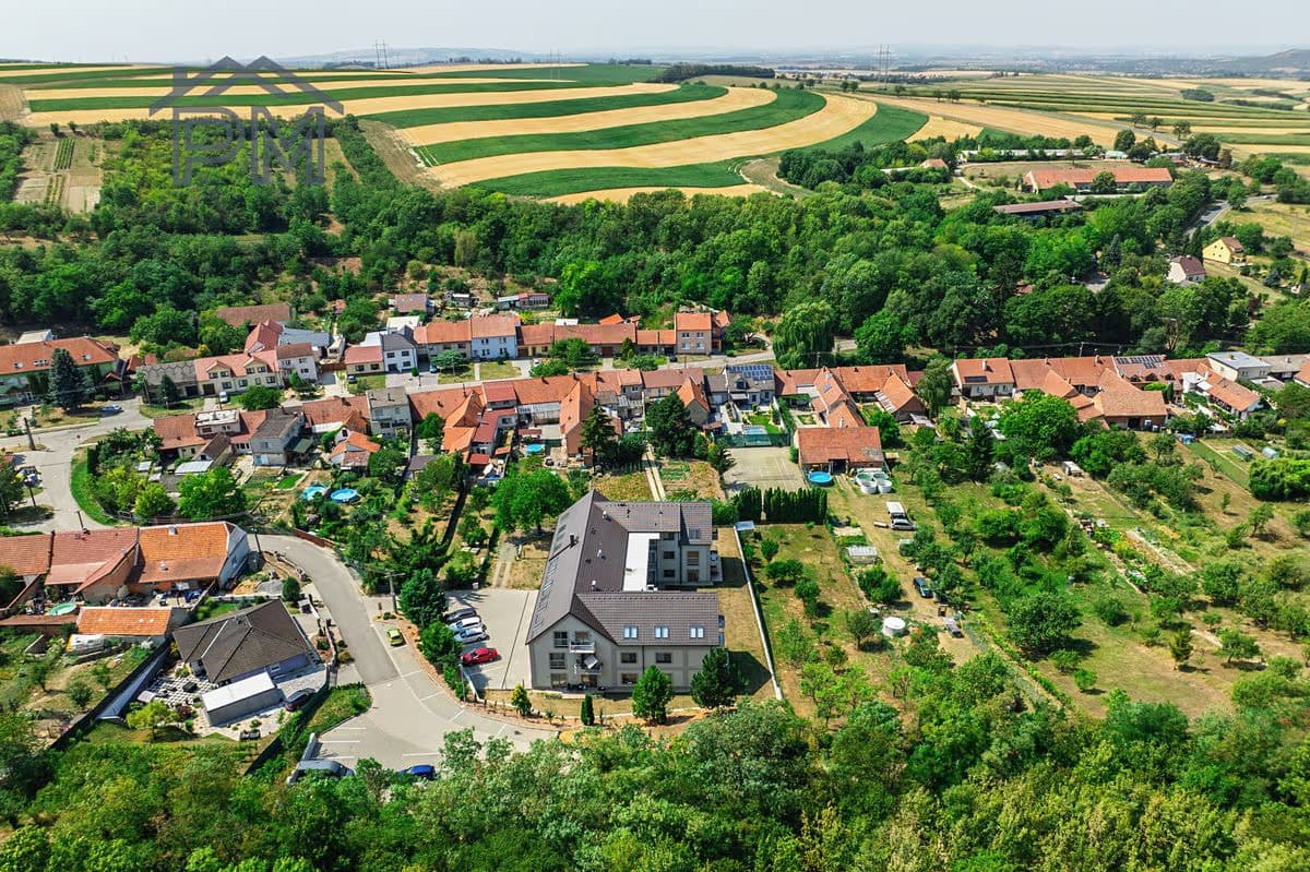 Letecký pohled na Milešovice s domem na okraji obce, kolem pole a zeleň