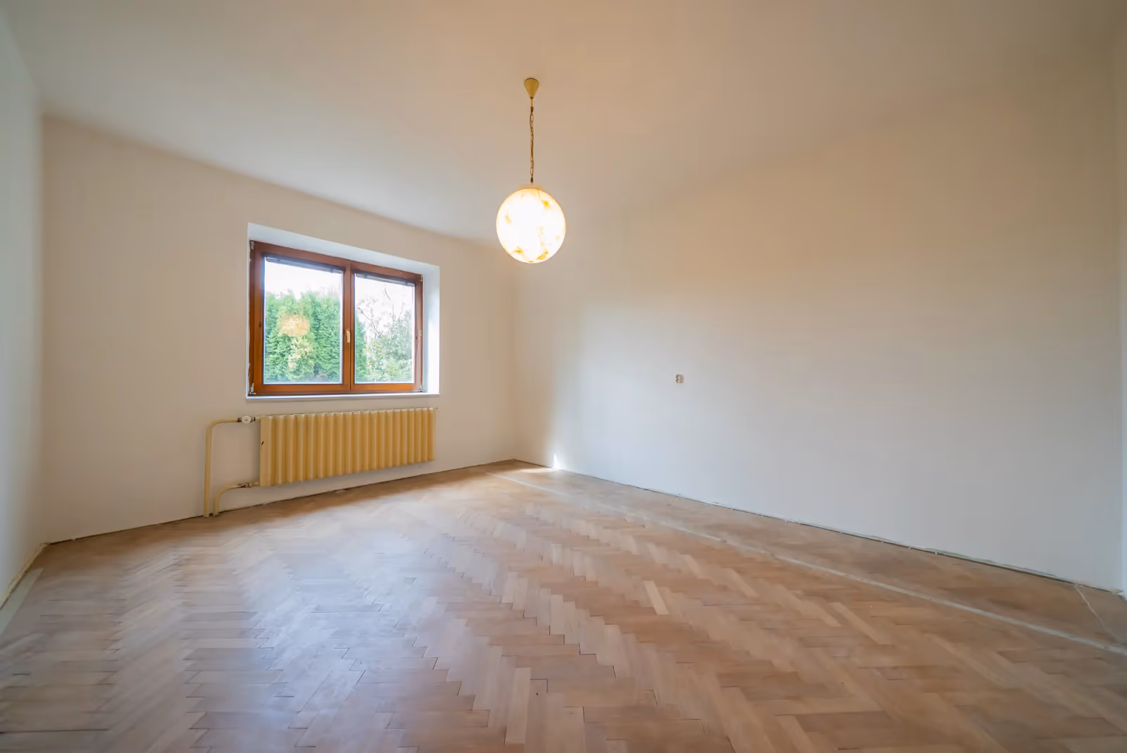 Druhý pohled do pokoje v přízemí — parkety a okno do zeleně